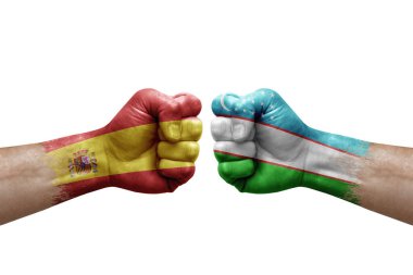 Two hands punch to each others on white background. Country flags painted fists, conflict crisis concept between spain and uzbekistan