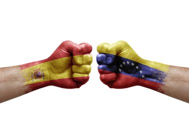 Two hands punch to each others on white background. Country flags painted fists, conflict crisis concept between spain and venezuela