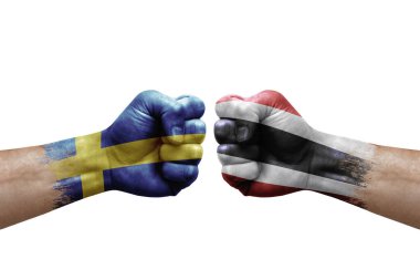 Two hands punch to each others on white background. Country flags painted fists, conflict crisis concept between sweden and thailand
