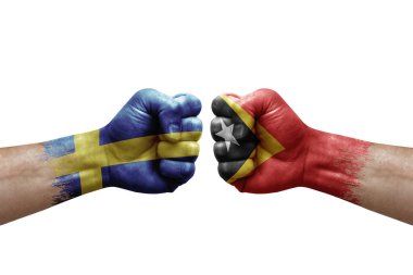 Two hands punch to each others on white background. Country flags painted fists, conflict crisis concept between sweden and timor leste