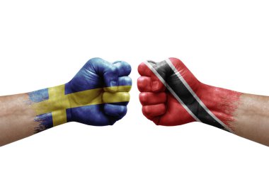 Two hands punch to each others on white background. Country flags painted fists, conflict crisis concept between sweden and tobago