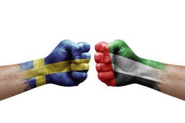 Two hands punch to each others on white background. Country flags painted fists, conflict crisis concept between sweden and united arab emirates