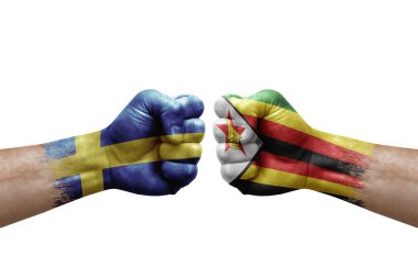 Two hands punch to each others on white background. Country flags painted fists, conflict crisis concept between sweden and zimbabwe