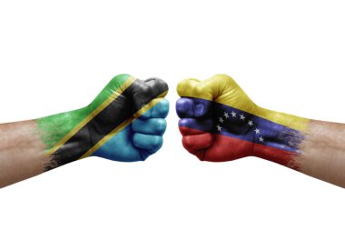 Two hands punch to each others on white background. Country flags painted fists, conflict crisis concept between tanzania and venezuela