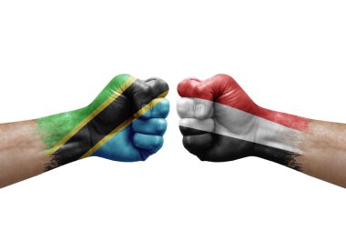 Two hands punch to each others on white background. Country flags painted fists, conflict crisis concept between tanzania and yemen
