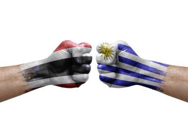 Two hands punch to each others on white background. Country flags painted fists, conflict crisis concept between thailand and uruguay