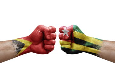 Two hands punch to each others on white background. Country flags painted fists, conflict crisis concept between timor leste and togo