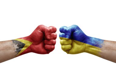 Two hands punch to each others on white background. Country flags painted fists, conflict crisis concept between timor leste and ukraine