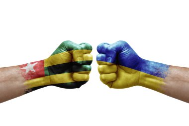 Two hands punch to each others on white background. Country flags painted fists, conflict crisis concept between togo and ukraine