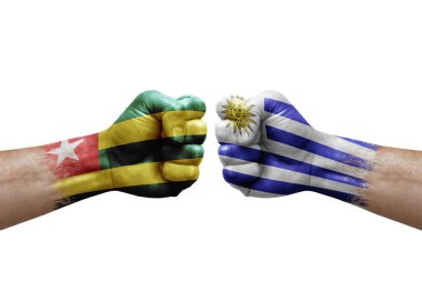 Two hands punch to each others on white background. Country flags painted fists, conflict crisis concept between togo and uruguay
