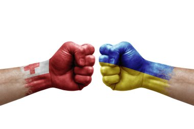 Two hands punch to each others on white background. Country flags painted fists, conflict crisis concept between tonga and ukraine