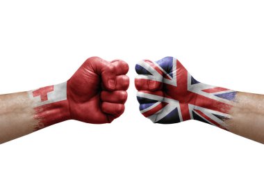 Two hands punch to each others on white background. Country flags painted fists, conflict crisis concept between tonga and united kingdom