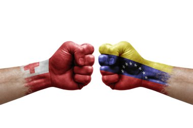 Two hands punch to each others on white background. Country flags painted fists, conflict crisis concept between tonga and venezuela