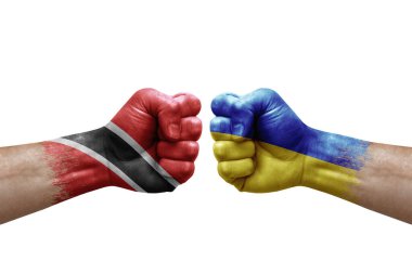 Two hands punch to each others on white background. Country flags painted fists, conflict crisis concept between trinidad tobago and ukraine