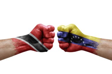 Two hands punch to each others on white background. Country flags painted fists, conflict crisis concept between trinidad tobago and venezuela