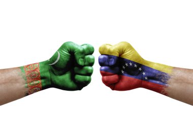 Two hands punch to each others on white background. Country flags painted fists, conflict crisis concept between turkmenistan and venezuela