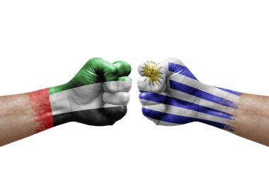Two hands punch to each others on white background. Country flags painted fists, conflict crisis concept between uae and uruguay