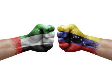 Two hands punch to each others on white background. Country flags painted fists, conflict crisis concept between uae and venezuela