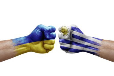 Two hands punch to each others on white background. Country flags painted fists, conflict crisis concept between ukraine and uruguay