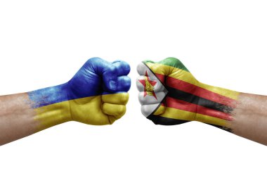 Two hands punch to each others on white background. Country flags painted fists, conflict crisis concept between ukraine and zimbabwe