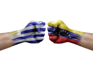 Two hands punch to each others on white background. Country flags painted fists, conflict crisis concept between uruguay and venezuela