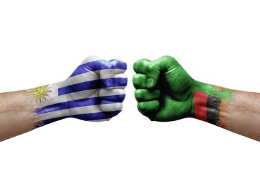 Two hands punch to each others on white background. Country flags painted fists, conflict crisis concept between uruguay and zambia