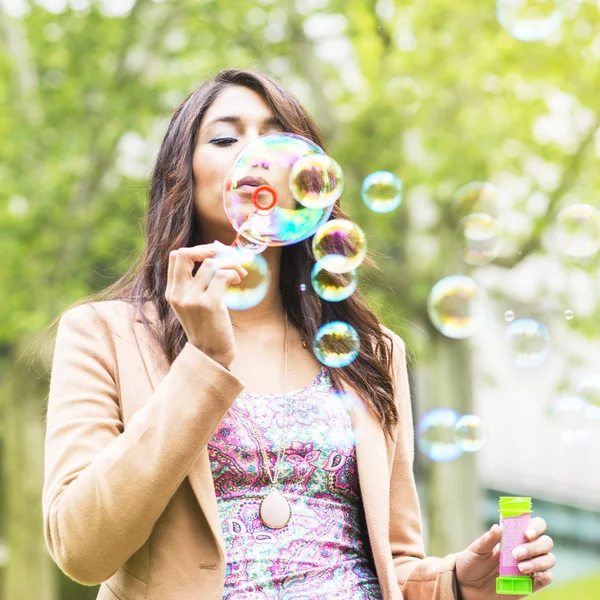 Bela jovem mulher soprando bolhas . — Fotografia de Stock