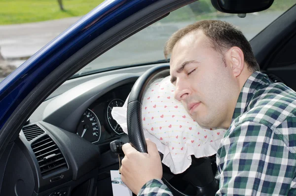 Uitgeput man is slapen in een auto. — Stockfoto