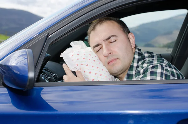 Uitgeput man is slapen in een auto. — Stockfoto