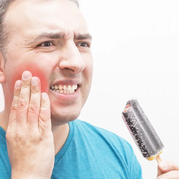 冷たいアイスクリームを食べる歯痛を持つ男. ロイヤリティフリーのストック写真