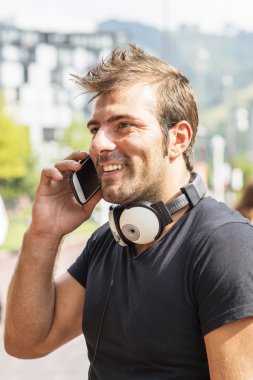 telefonla konuşan adam gülümsüyor.