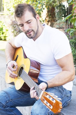 adam parkta klasik gitar çalıyor..