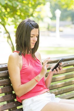 Parkta akıllı telefon kullanan kadın..