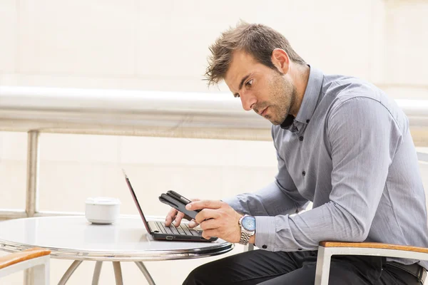 Affärsman som arbetar dator och telefon. — Stockfoto