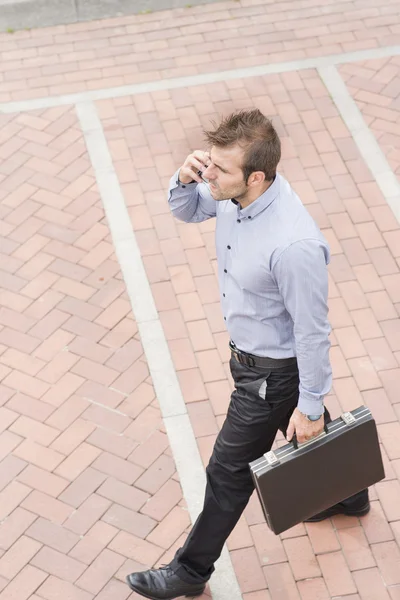 Zakenman met werkmap wandelen in de straat. — Stockfoto