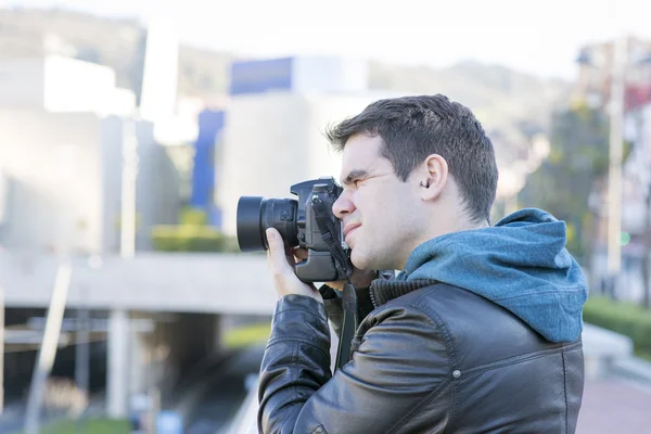 Portrét fotografa s kamerou v akci v ulici. — Stock fotografie