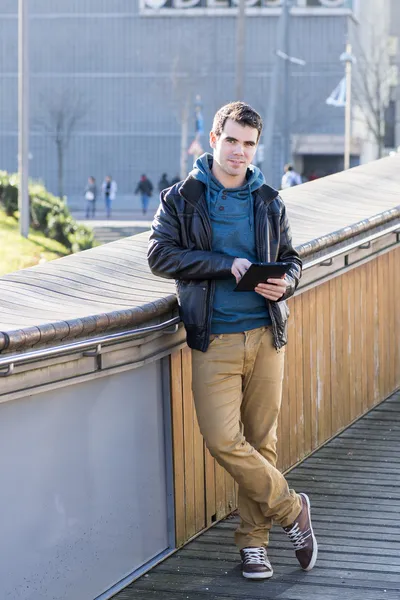 Man met tablet pc te kijken naar de camera in de straat. — Stockfoto