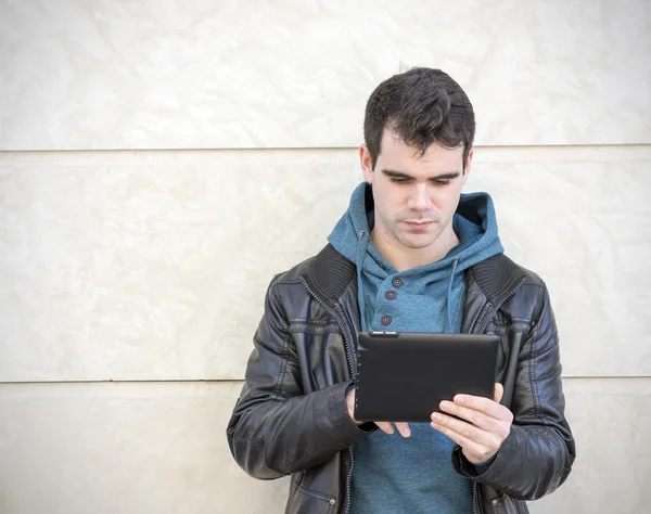 Man met behulp van tablet pc op grijze achtergrond. — Stockfoto