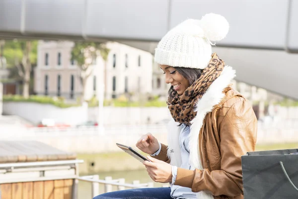 Smiling woman using tablet computer in the street. — Stock Photo, Image