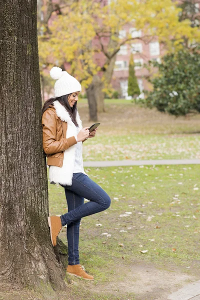 Smiling woman using tablet computer in the park. — Stock Photo, Image