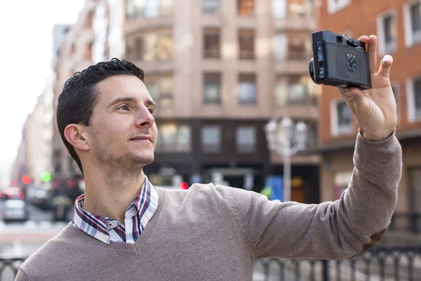 Porträt eines Mannes, der mit Retro-Kamera auf der Straße fotografiert. — Stockfoto