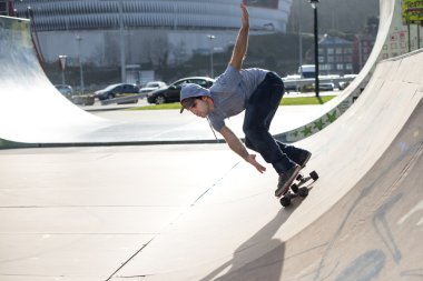 Skateboarder in action on skateboard track. clipart