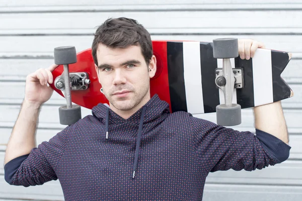 Man portrait holding skateboard on background. — Stock Photo, Image