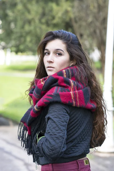 Retrato de mujer atractiva con bufanda mirando hacia atrás, al aire libre . — Foto de Stock