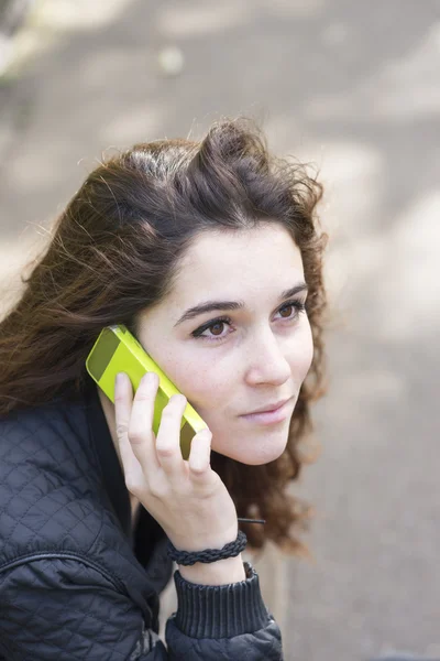 Portrait of girl talking by phone and looking away, outdoor. — Stock Photo, Image