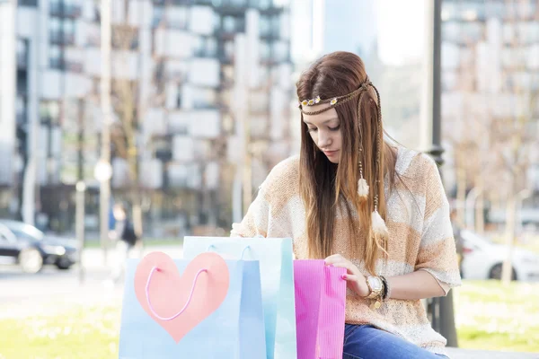 Portrait of hippie styling woman looking shopping bags, outdoor. — Stock Photo, Image