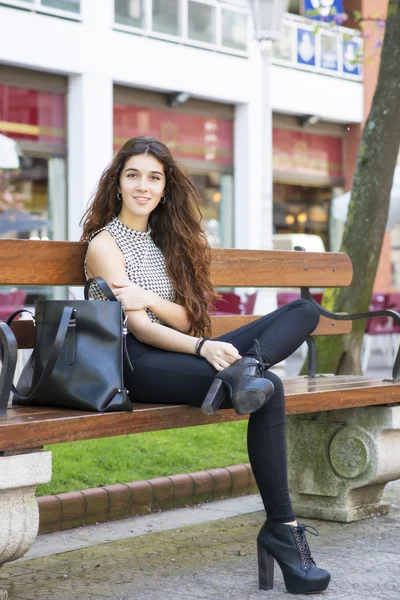 Mujeres elegantes sonrientes sentadas en el banco en la calle . —  Fotos de Stock