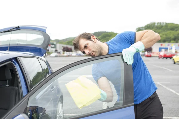 Man cleaning car glass with sponge. — Stock Photo, Image