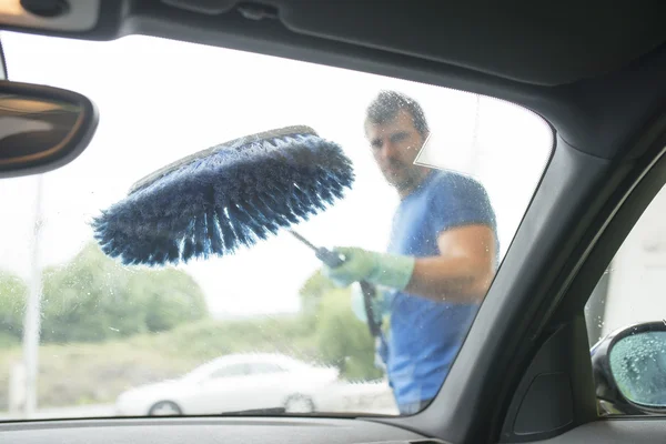 Man cleaning car glass with brush. — Stock Photo, Image