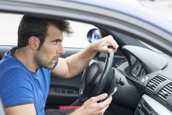 Man rijdende auto en bedrijf telefoon, gevaarlijke concept. — Stockfoto
